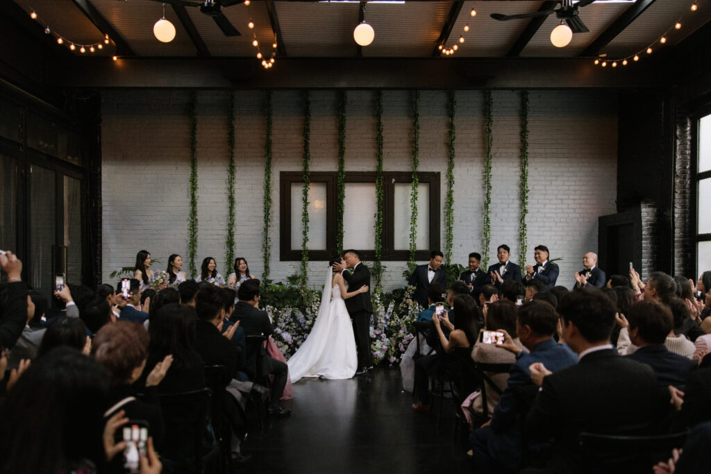 Bride and groom sharing first kiss as a married couple