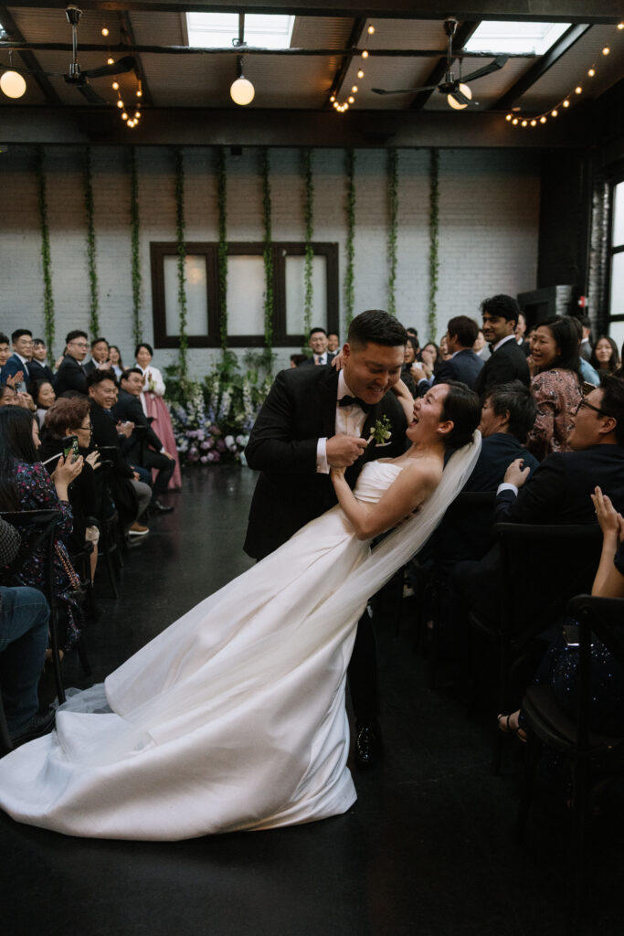 Groom dipping the bride in the aisle