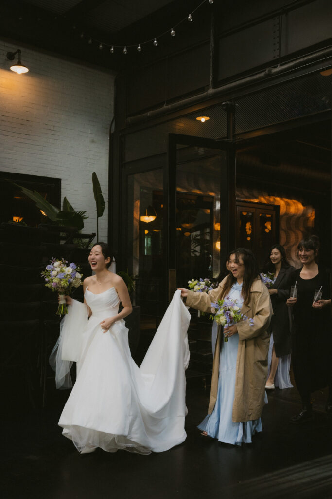 Bride entering the room laughing with bridesmaids
