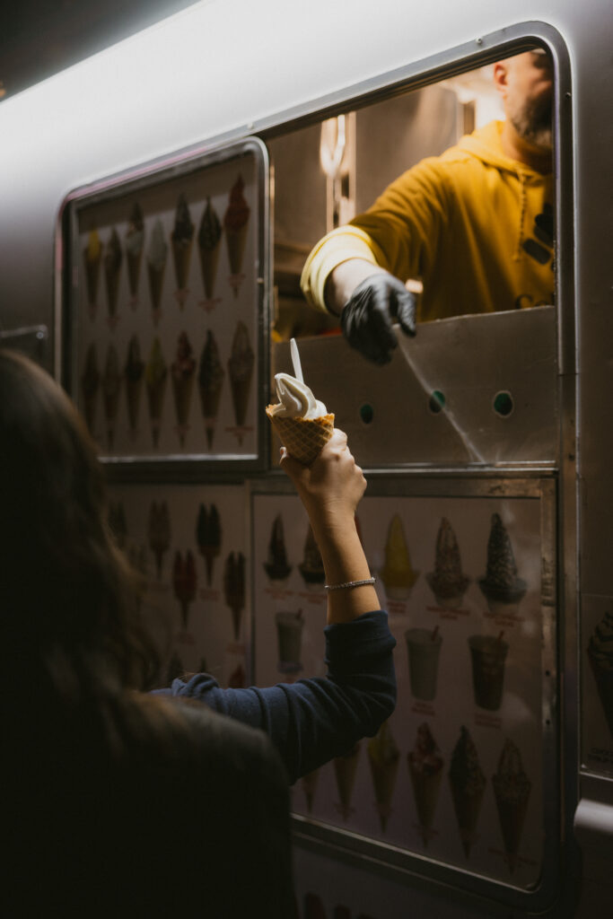 Guest being handed ice cream from ice cream truck