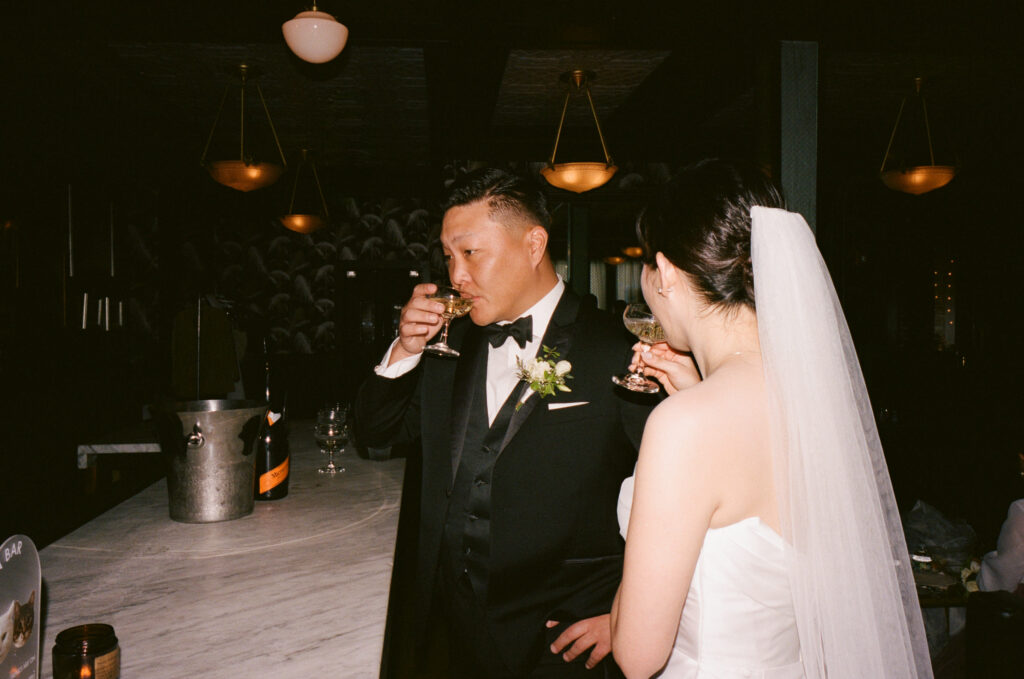 Bride and groom drinking champagne