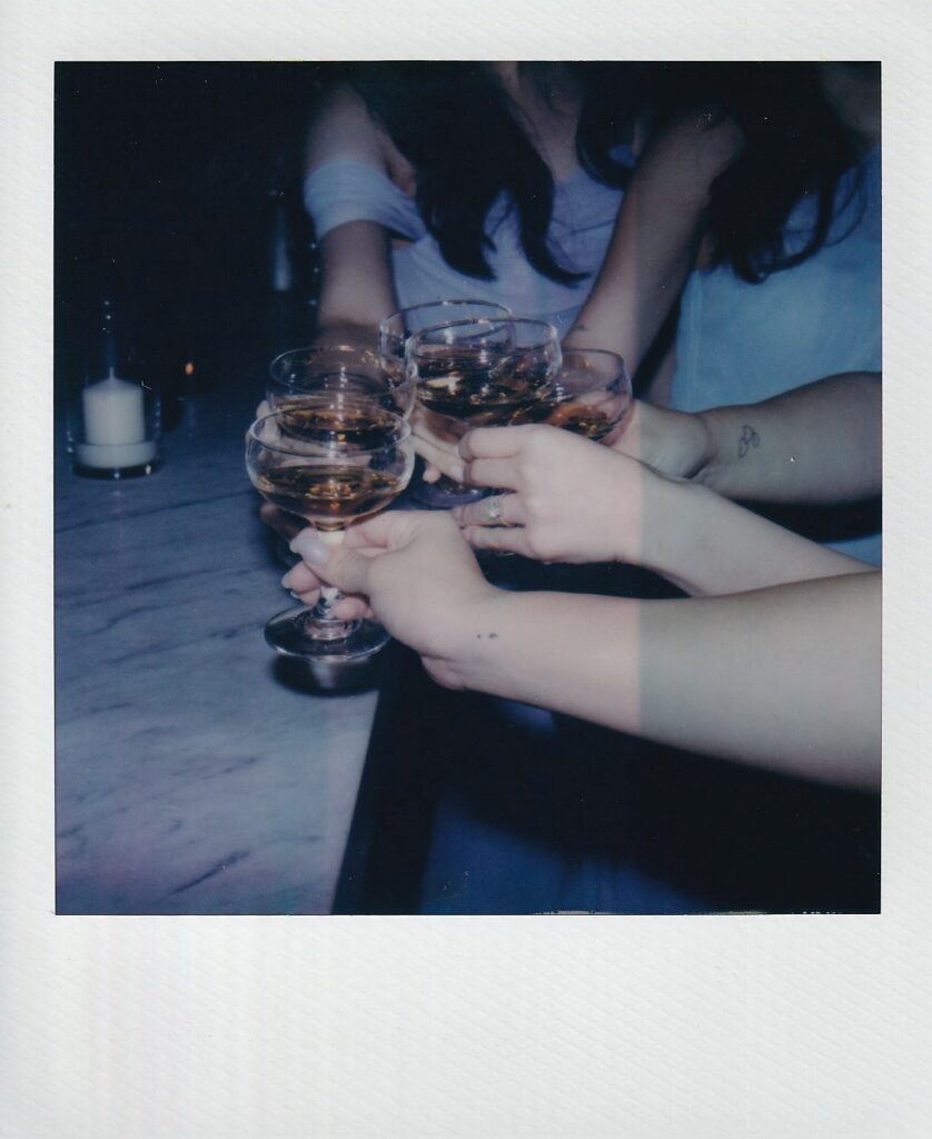 Polaroid of bride and bridesmaids clinking glasses