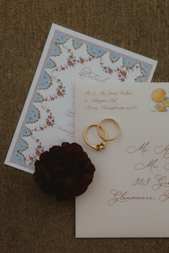Flat Lay of Wedding Invitation, Envelope, and Wedding Rings