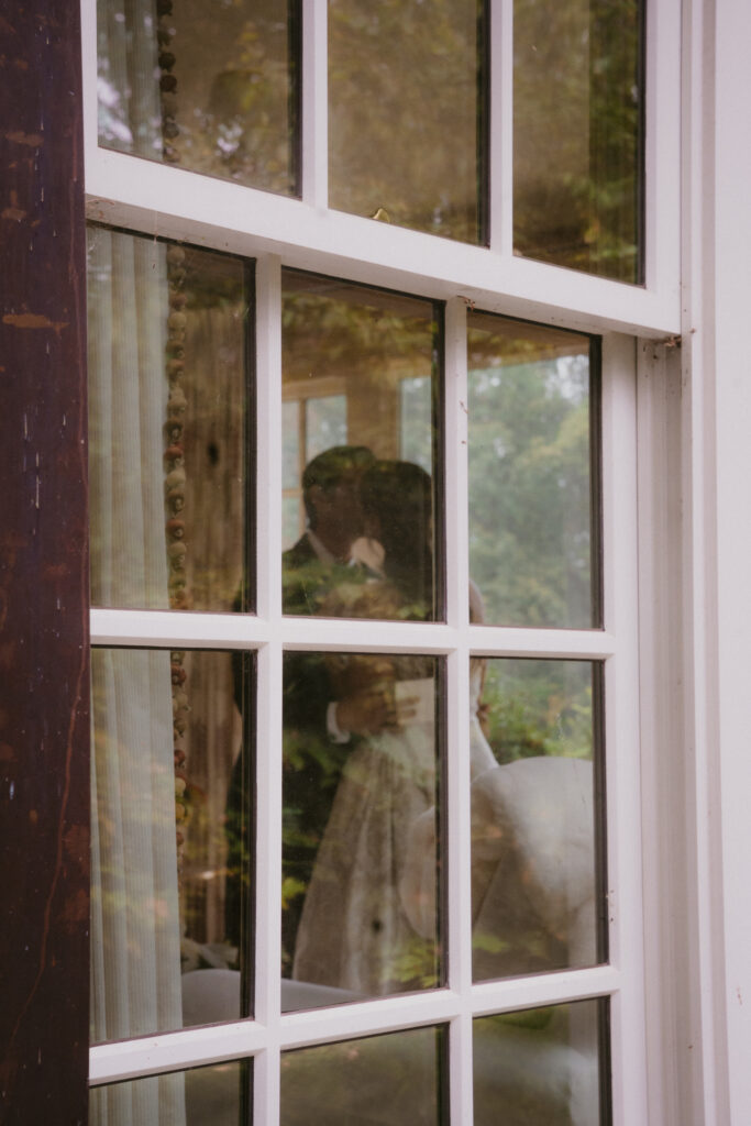 Bride and groom kissing, shot through a window 