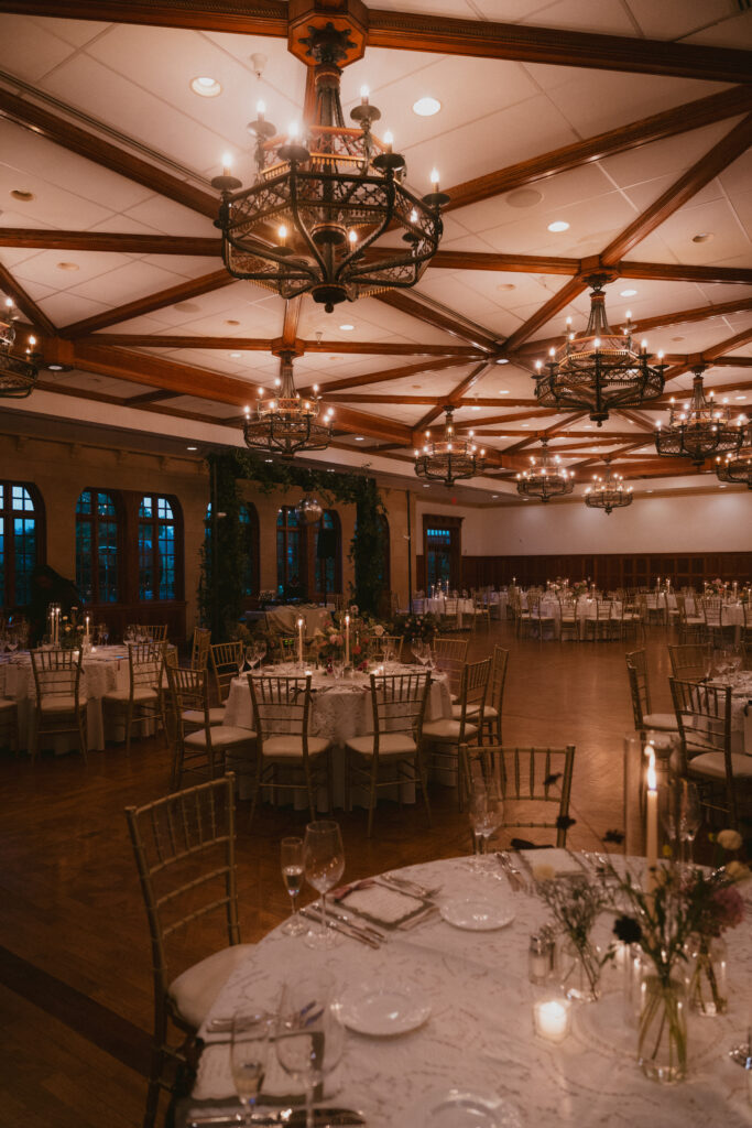 Reception ballroom with round tables and chandeliers