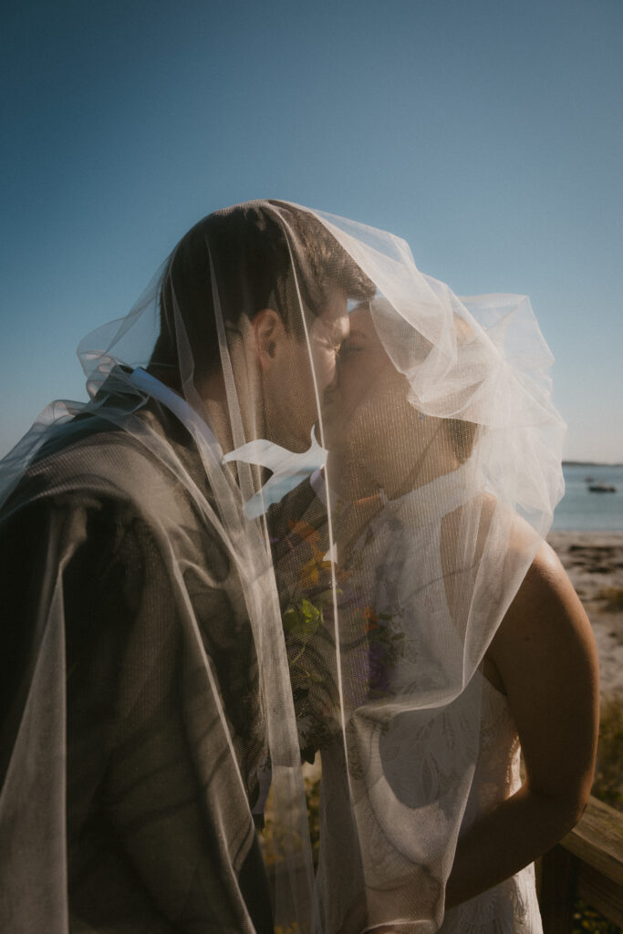 Bride and groom kissing under the veil