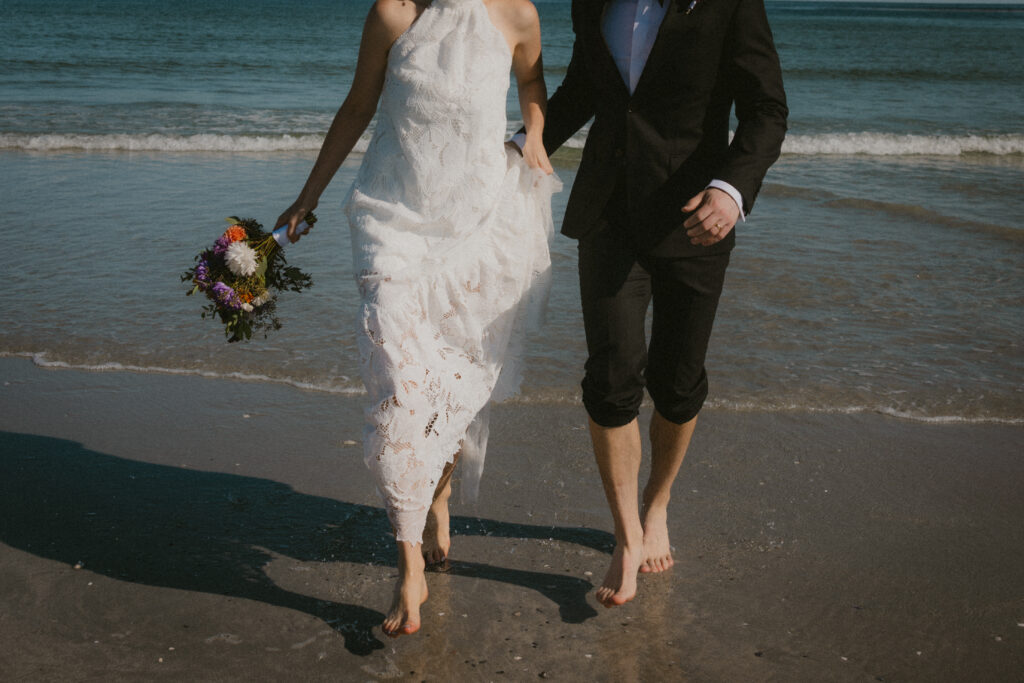 Bride and groom running in the water at Goose Rocks Beach