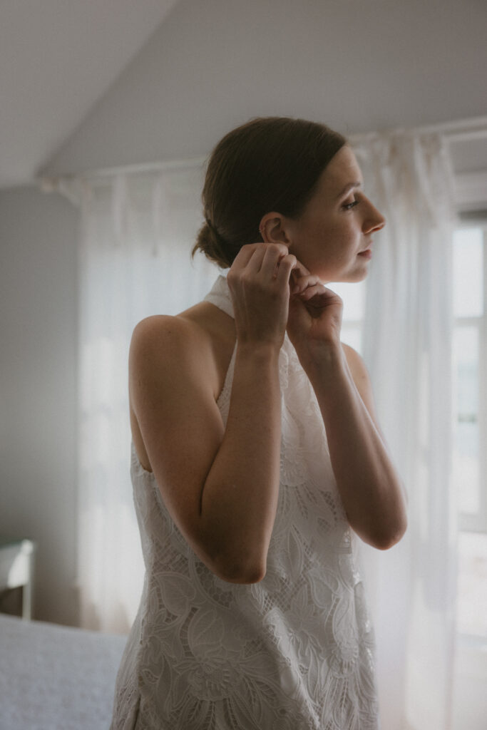 Bride putting on earrings 
