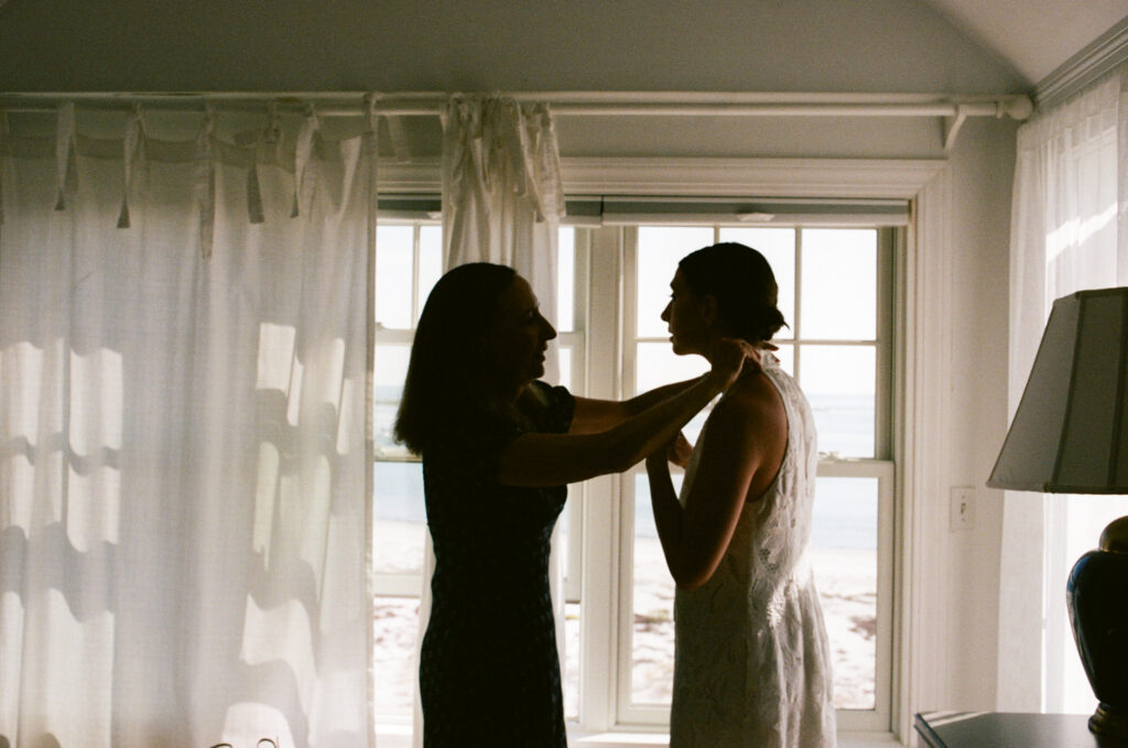 Film image of bride getting ready with the help of the mother of the bride 