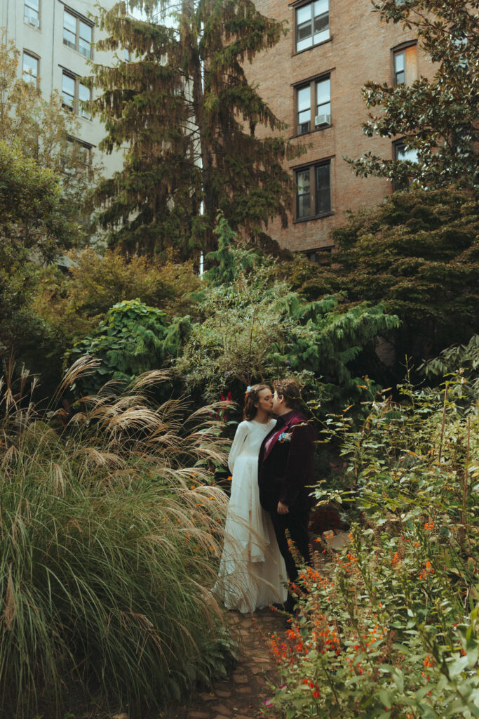 Brides kissing in the middle of a garden