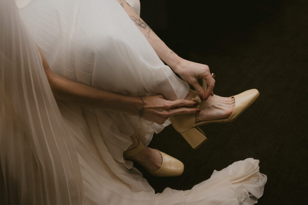 Close up photo of bride putting on her heels