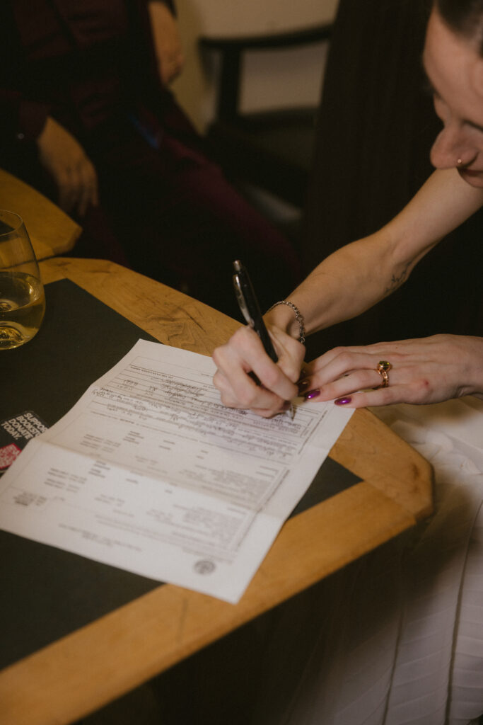 Close up of bride signing the marriage license 