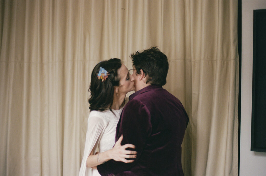 Bride kissing the other bride on the cheek during the first look