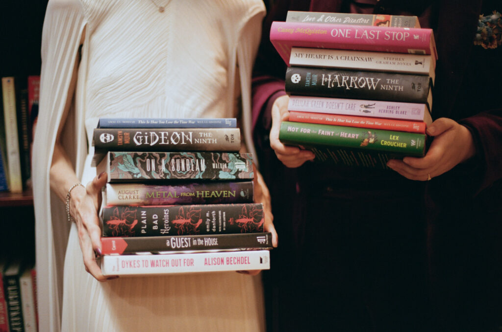 Close up of brides holding stacks of their favorite books at their housing works bookstore wedding