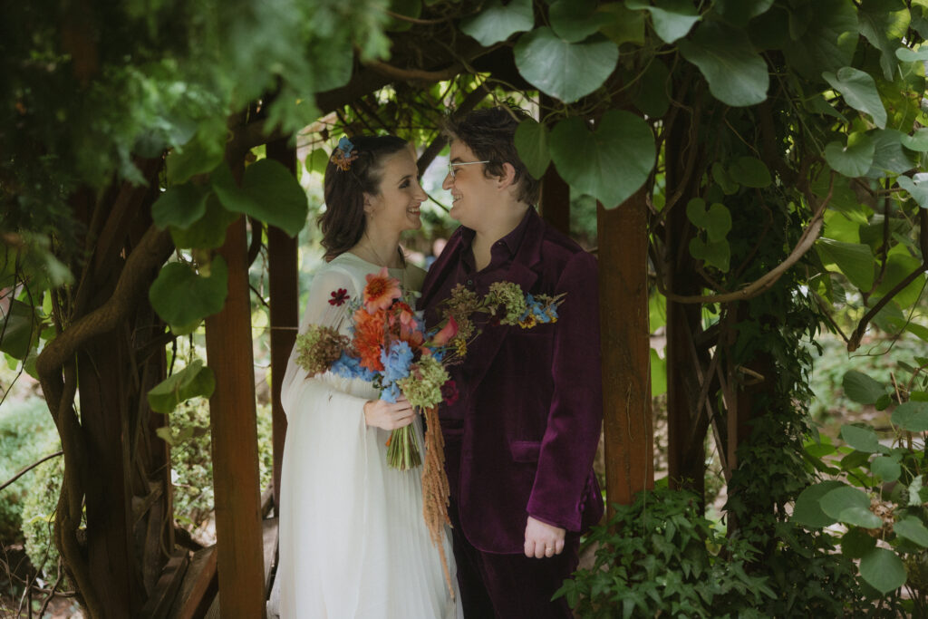 Brides standing under a gazebo looking at each other 