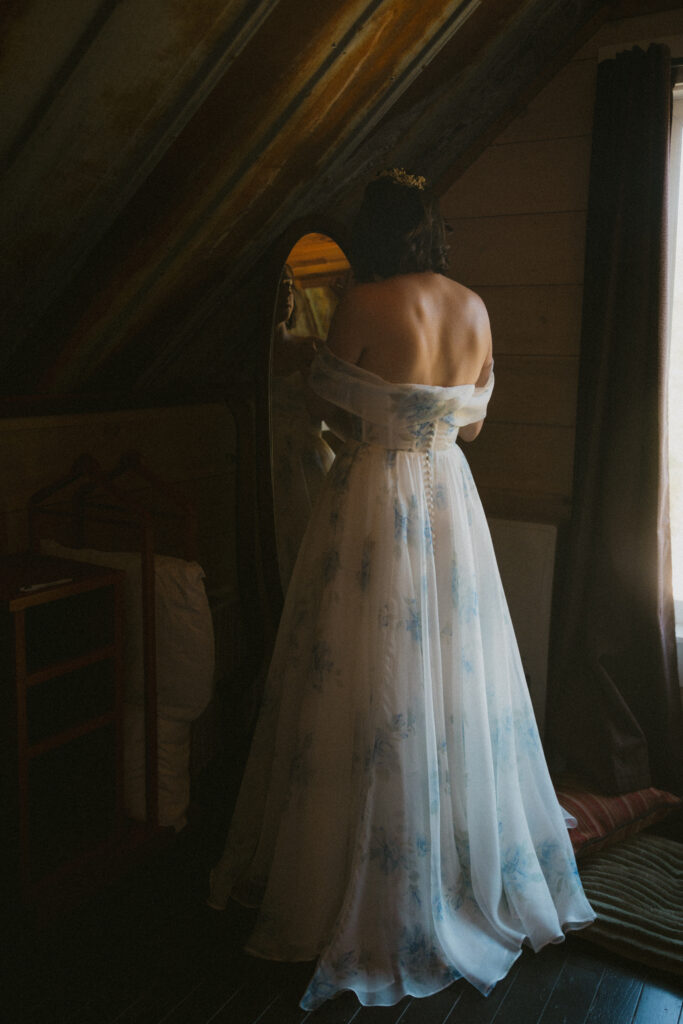 Bride getting ready in front of a mirror, shot from behind
