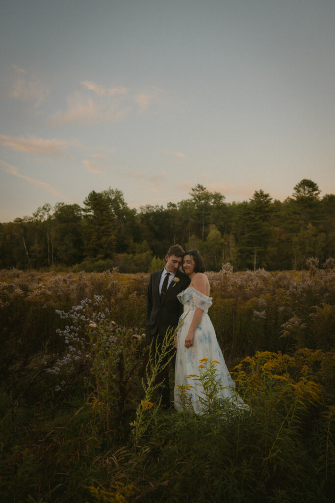 Bride and groom standing in a wildflower meadow