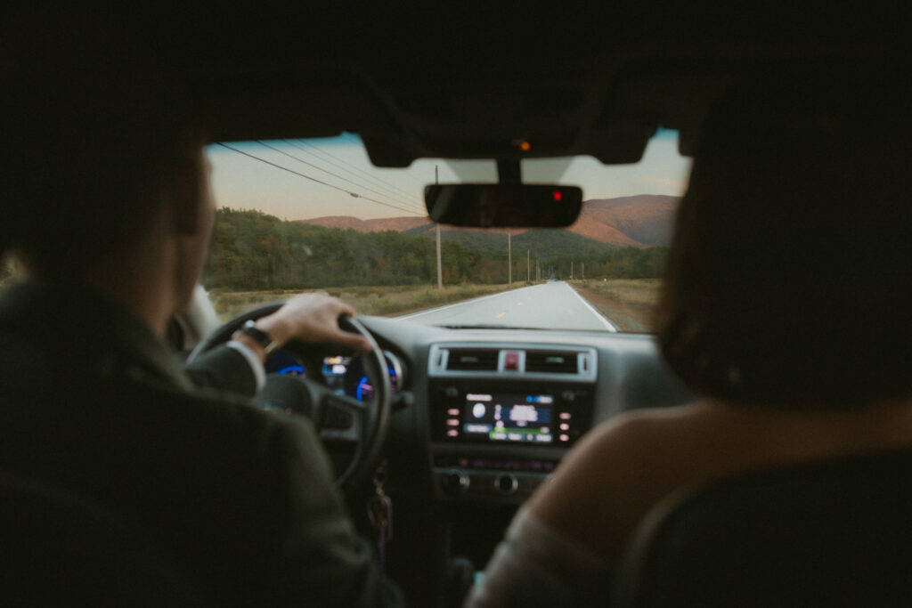 Photo of bride and groom in their car  after the ceremony, taken from the backseat