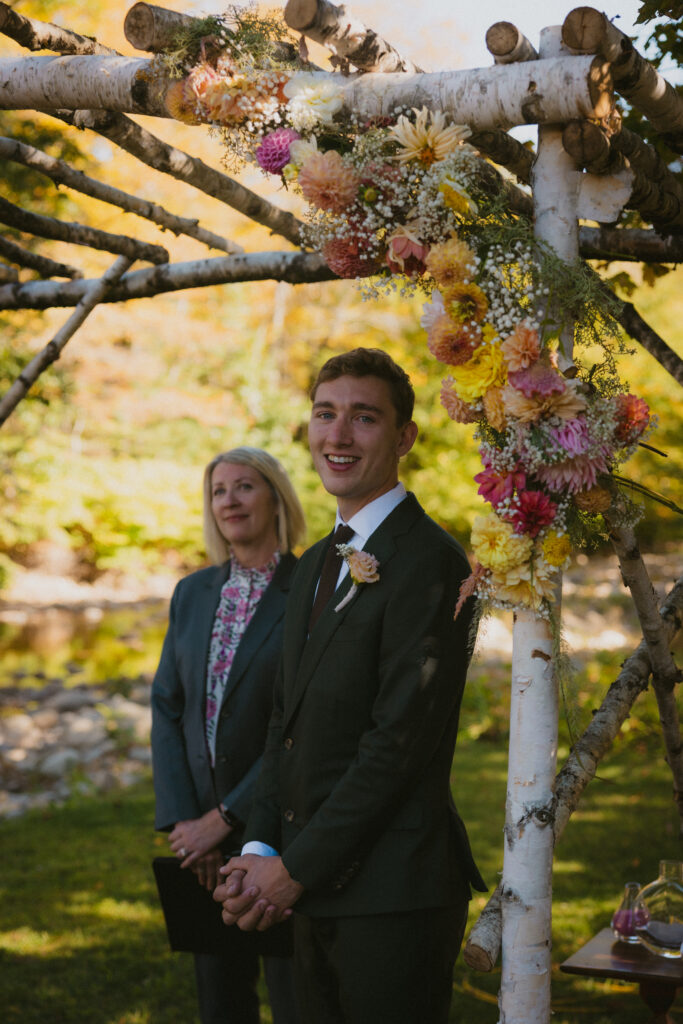 Groom watching the bride walk down the aisle toward him