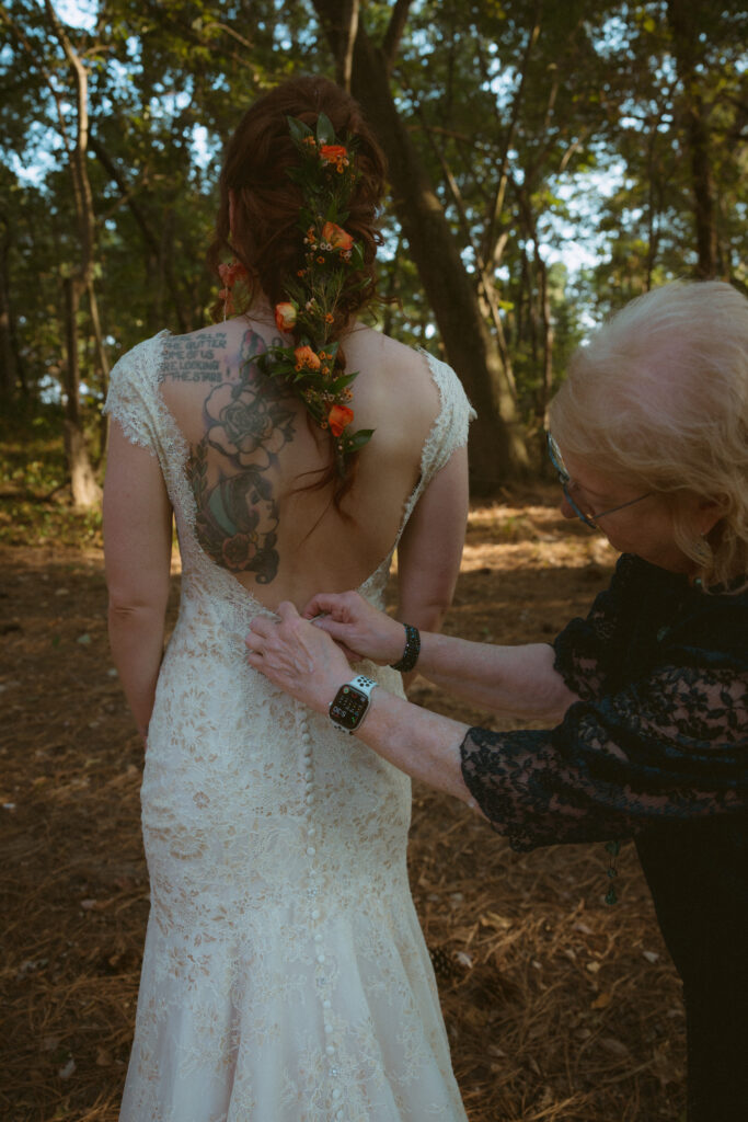 Bride's grandmother buttoning the back of her dress