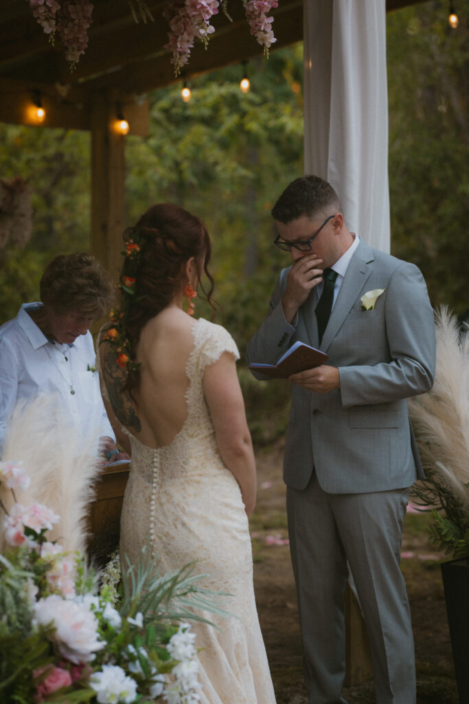 Groom reading his vows at a summer camp wedding venue
