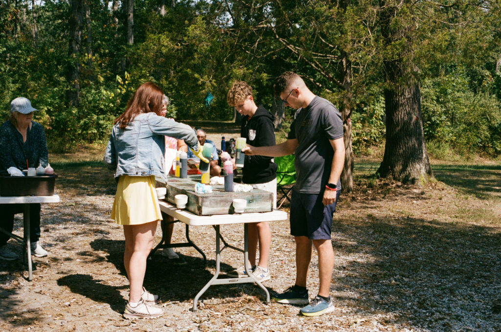 Bride and groom tie-dying at summer camp wedding venue