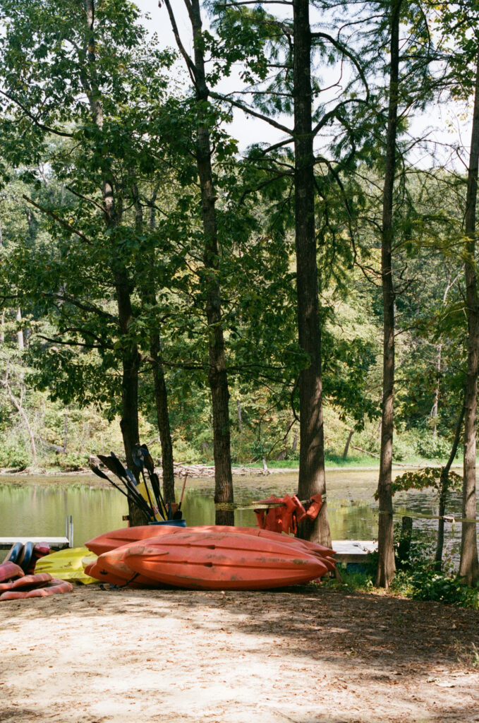 Kayaking equipment in front of a lake at a summer camp wedding venue