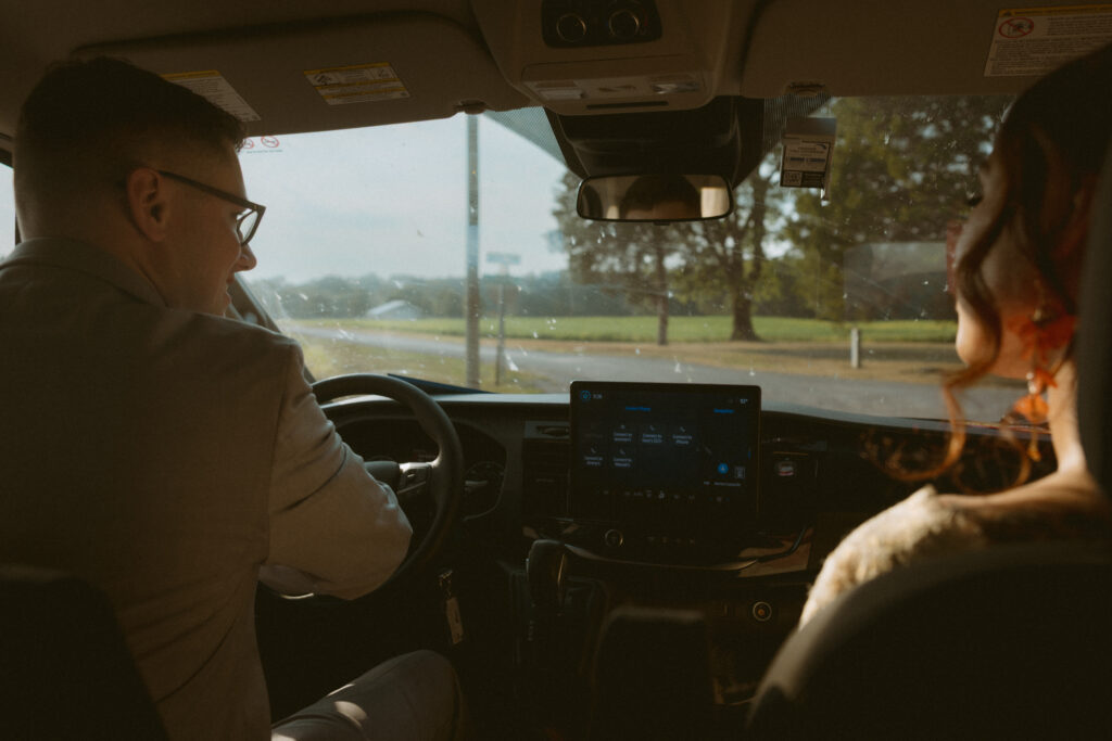 Bride and groom driving in the car, taken from the backseat