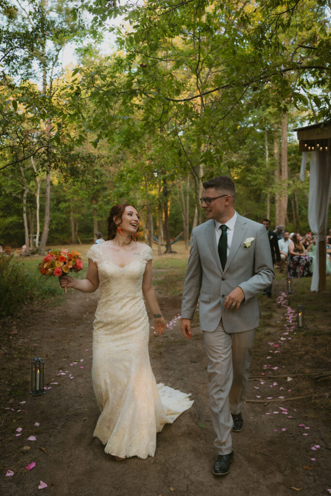 Bride and groom walking away smiling after the wedding ceremony