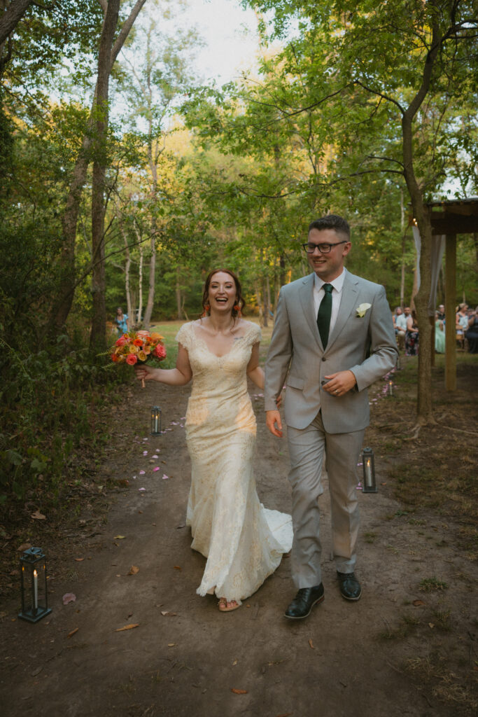 Bride and groom walking away smiling after the wedding ceremony
