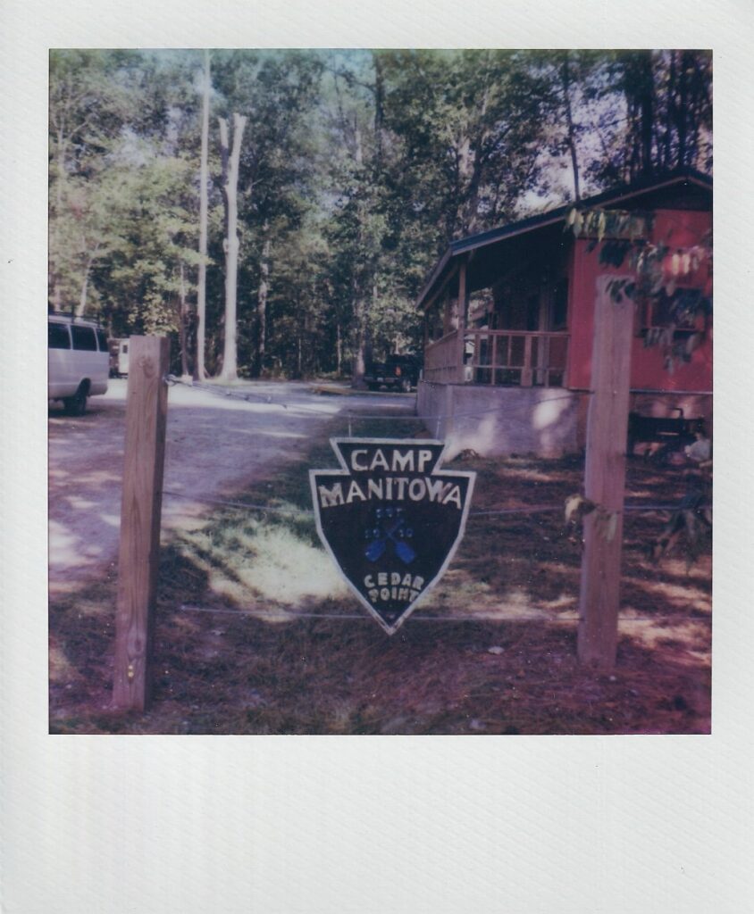 Polaroid of camp sign at a summer camp wedding venue