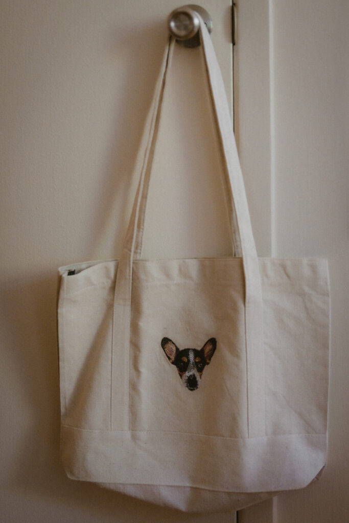 Detail shot of a custom embroidered tote bag with a couple's dog's face 