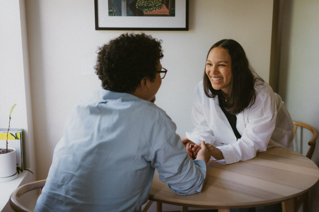 Engaged couple holding hands and smiling across a table