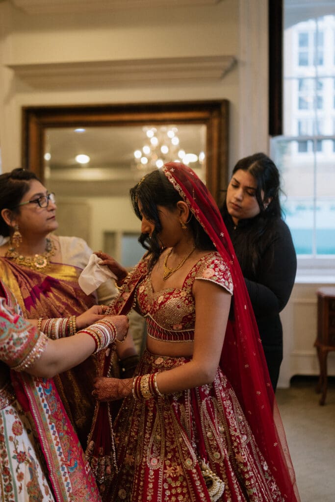 Bride getting dressed in her Indian wedding dress