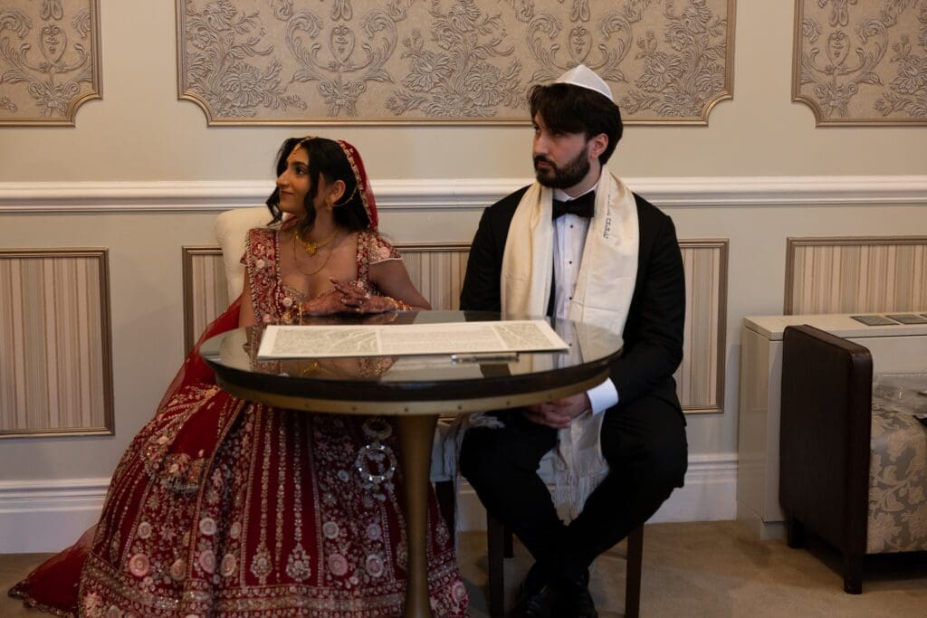 Bride and groom sitting during the Ketubah signing