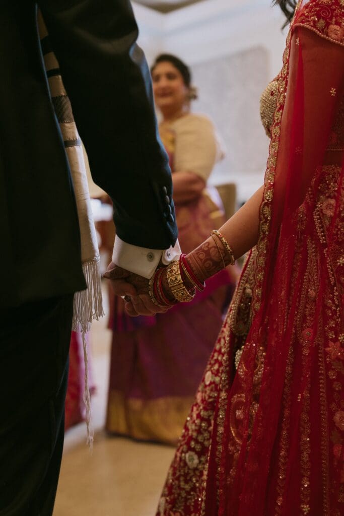 Bride and groom holding hands during the Ketubah signing