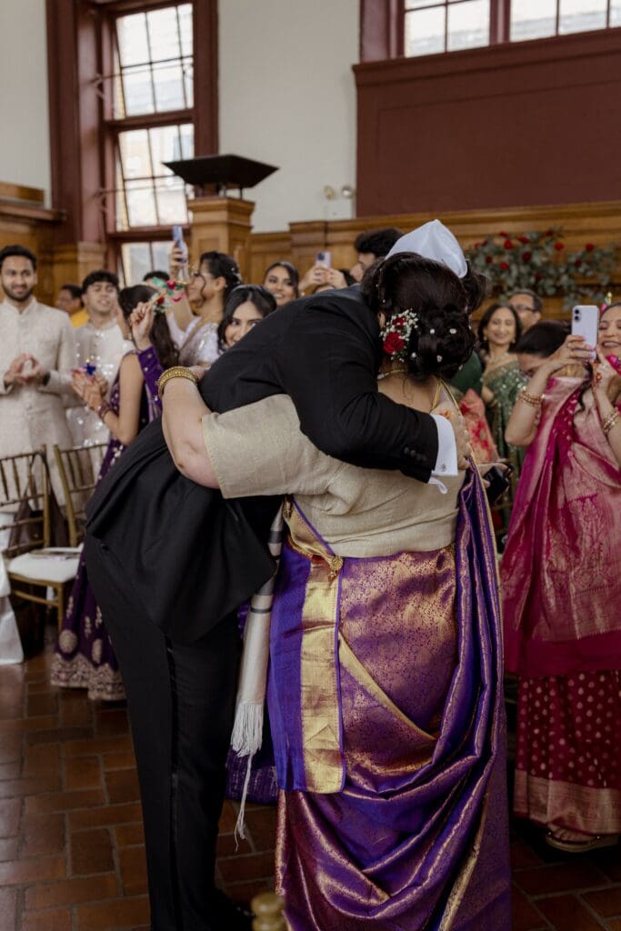Bride's mother welcoming the groom during the ceremony at a Hindu Jewish wedding