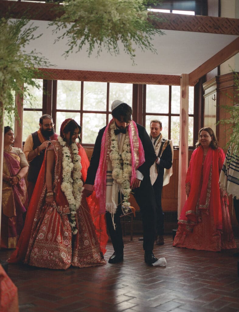 Groom smashing the glass during a Hindu Jewish wedding
