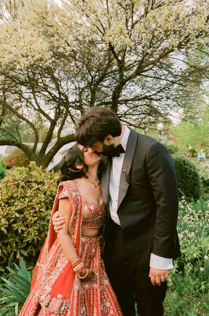 Bride and groom kissing in a garden