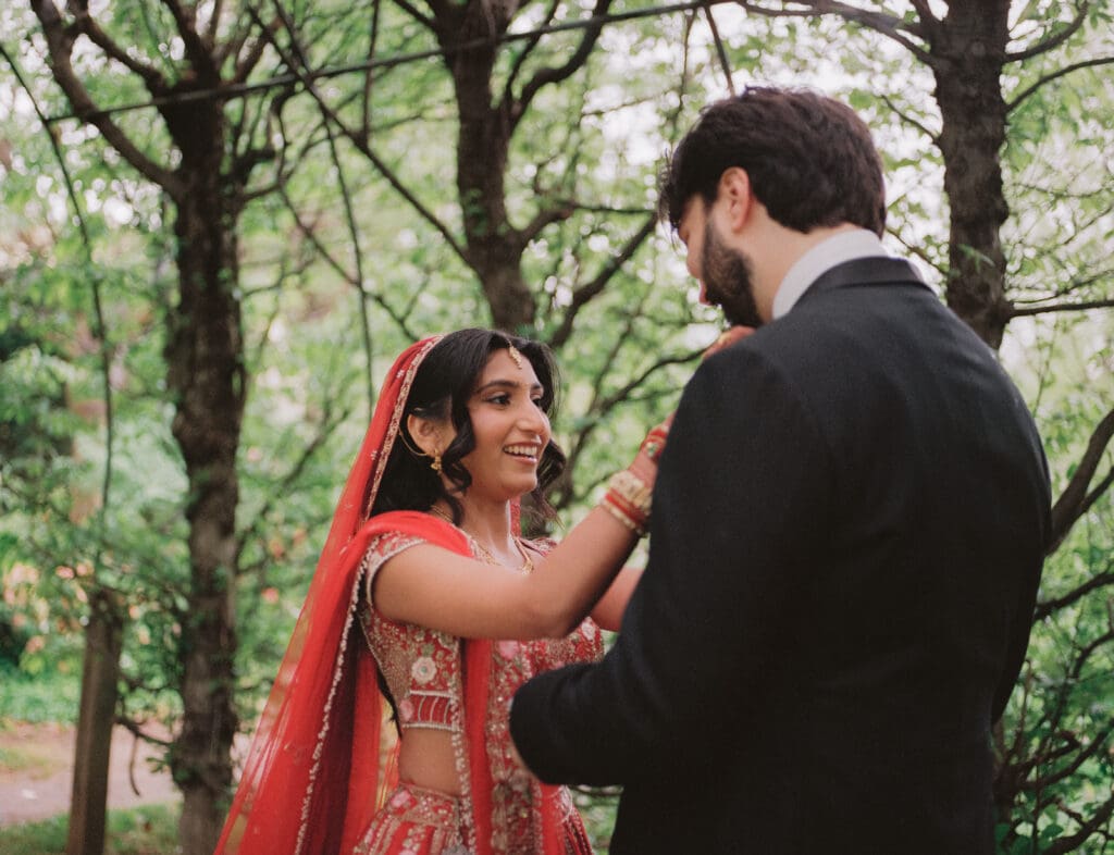 Bride fixing the groom's tie during the first look at a Hindu Jewish wedding