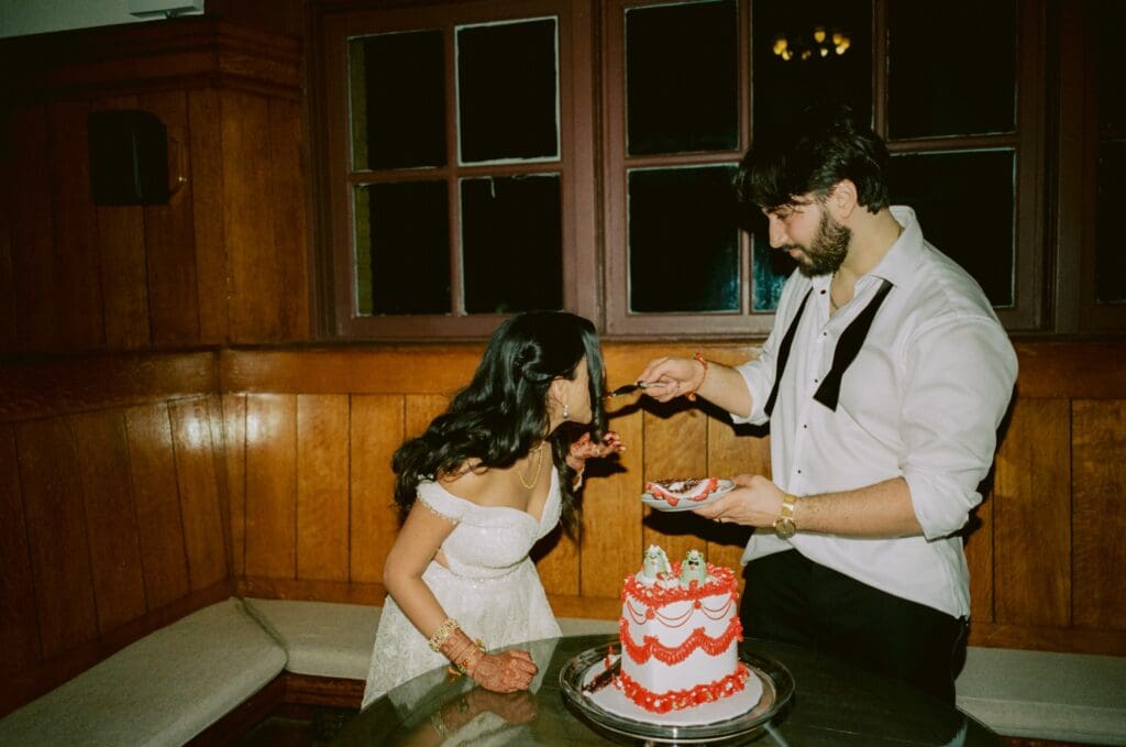 Groom feeding the bride cake during the cake cutting