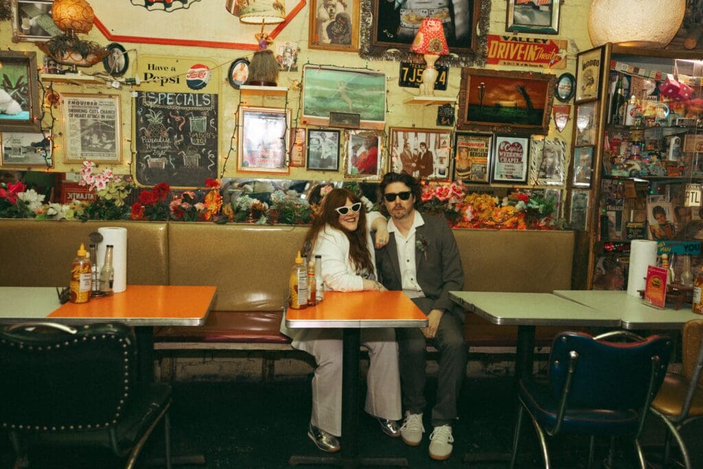 Bride and groom sitting at a booth in Trailer Park Lounge