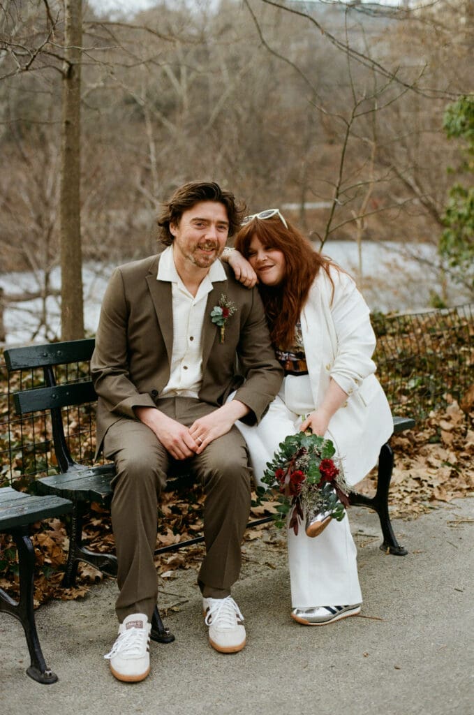 Bride and groom sitting on a bench in Central Park