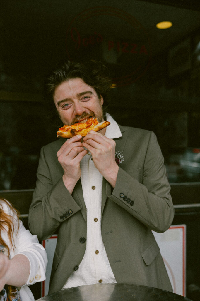 Groom eating a slice of pizza