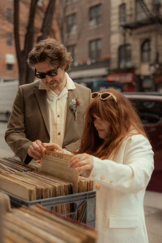 Bride and groom looking at records outside a record store