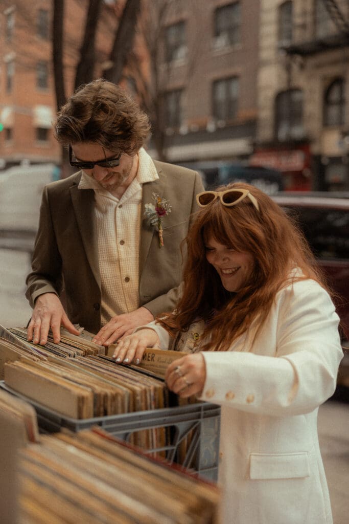 Bride and groom looking at records outside a record store