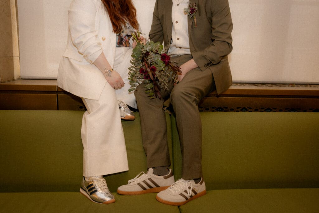 Couple sitting on the green couches at their manhattan city hall elopement