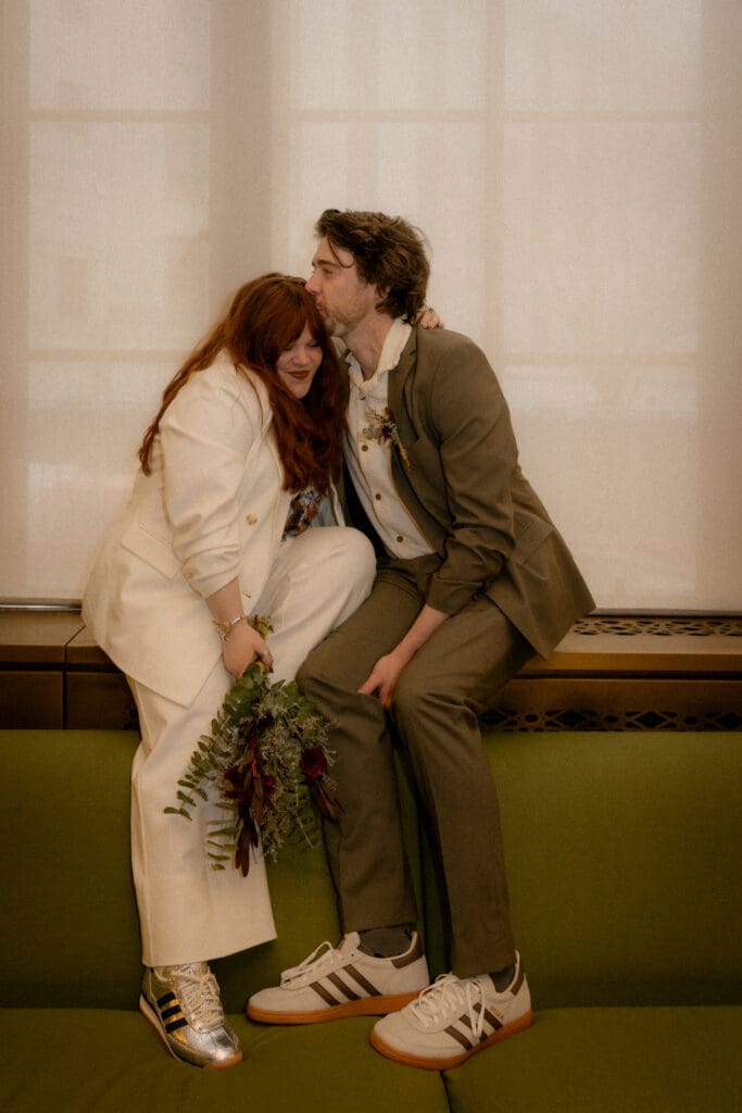 Couple sitting on the green couches at their manhattan city hall elopement