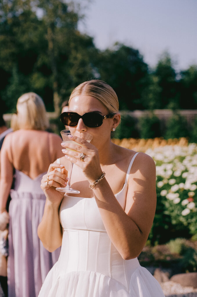Bride sipping a drink during cocktail hour
