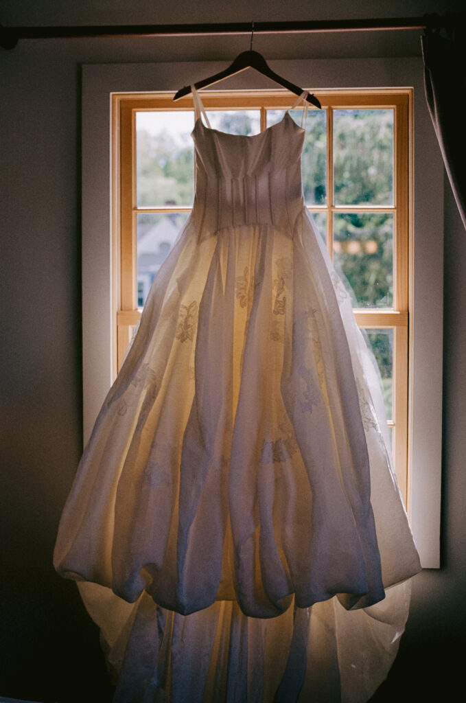 Wedding dress hung in front of a mirror